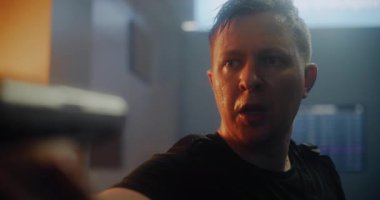 Epic Action Movie Scene: Black Taktik Giyimli Yorgun Erkek Suçlu Ağır Nefes alıyor, Silahı doğrultuyor, Düşmanla Konuşuyor. Karanlık Ofis Binası 'nda Gangster Saldırısı Tanınmayan Kişi.