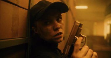 Taktik Ekipman 'daki Kadın Gizli Ajanın Kapağı Gizleniyor, Bir Tabanca Tutuyor, Katille Konuşuyor. Memur Karanlık Depo 'da suçluya saldırmaya hazırlanıyor. Epic Action Film Scene. Sıcak. Bak..