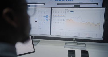 Çevrimiçi Ticaret Yazılımlı Çoklu Monitör Masaüstü Sistemi ile bilgisayar. Gerçek zamanlı borsa analizi, borsa grafikleri, borsa analizi. Ofiste çalışan Afro-Amerikan Yatırım Ajanı.