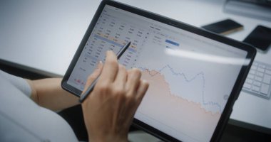 Dijital Tablet ve Stylus 'u kullanarak Kadın Borsası Borsası İzleme ve Analiz Etme, Çevrimiçi Ticaret Uygulamasında Piyasa Grafikleri. Ofiste çalışan Profesyonel Yatırım Ajanı. Kapat..