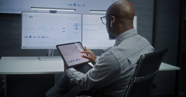 Dijital Tablet ve Bilgisayarda Çoklu İzleyici Masaüstü ile Gerçek zamanlı borsa ve borsa grafiklerini izleyen Afro-Amerikan borsa simsarı. Ofiste çalışan Yatırım Ajanı. Yakınlaştır.