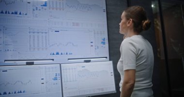 Kadın Borsası İşletmecisi Telefon görüşmesi yapıyor, Gerçek zamanlı hisse senetleri ve borsa grafiklerini Çoklu İzleme ve Dijital Tablet 'te izliyor. Yatırım Temsilcisi Kötü Ekonomi Haberleri Hakkında Stres Yaptı.