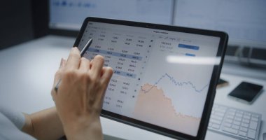 Gerçek zamanlı hisse senetlerini kontrol eden kadın finans analisti, Tablet Bilgisayar 'da Dijital Kalem Kullanarak Online Ticaret Mobil Uygulamasında borsa grafikleri. Finans bürosunda çalışan bir iş kadını. Kapat.