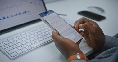Afro-Amerikan Finansal Analizci Smartphone ve Dijital Tablet 'in Online Ticari Uygulamasını Kullanarak Gerçek Zamanlı Borsa Çizelgelerini Kontrol Ediyor. Yatırım Bankası Ofisi 'nde çalışan bir işadamı. Kapat..
