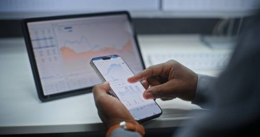 Smartphone ve Dijital Tablet Online Ticaret Uygulamasını kullanarak Afro-Amerikan Borsası Borsa Analizi ve Borsa Çizelgeleri. Ofiste çalışan Yatırım Ajanı. Kapat..