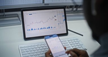 Smartphone ve Tablet Bilgisayar Online Ticaret Uygulaması 'nda Afro-Amerikan Borsa Borsası Analizi ve Borsa Çizelgeleri. Ofiste çalışan Yatırım Ajanı. Kapat..