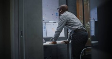 Çağrı sırasında borsa komisyoncusu bağırıyor, finansal zarara uğruyor, gerçek zamanlı hisse senedi ve borsa çizelgelerini takip ediyor. Afrika-Amerika Yatırım Ajanı Kötü Ekonomi Haberleri Hakkında Öfkeli.