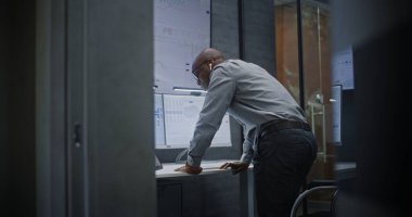 Çağrı sırasında borsa komisyoncusu bağırıyor, finansal zarara uğruyor, gerçek zamanlı hisse senedi ve borsa çizelgelerini takip ediyor. Afrika-Amerika Yatırım Ajanı Kötü Ekonomi Haberleri Hakkında Öfkeli.