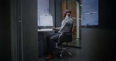 Heyecanlı Finansal Analistin Telefonu Var, Gerçek zamanlı Borsa Analizi Ofisteki Çoklu İzleme Bilgisayarında Değişim Listeleri. Mutlu Afrikalı Amerikalı İşadamı Başarılı Ticaret Anlaşması Yapıyor.