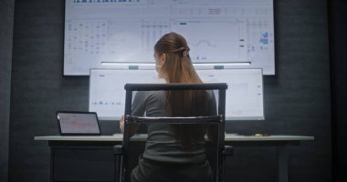 Multi-Monitor Workstation, Real-Time Stocks ve Exchange Market Charts ile bilgisayar üzerinde çalışan kadın finans analisti. Başarılı İşkadını Yatırım Bankası Ofisinde Gece Çalışıyor.