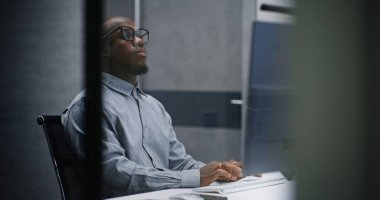 Afrikalı Amerikalı Profesyonel Finans Analisti ya da Borsa Simsarı Klavyede Yazıyor, Bilgisayar Kullanıyor. Gece Yatırım Bankası Ofisi veya Finans Ajansı 'nda başarılı bir İşadamı.