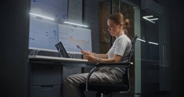 Kadın Finansal Analizci, Çoklu Dijital Aygıtlar ve Bilgisayarda Çoklu Monitör Çalışma İstasyonu ile Gerçek Zamanlı Borsa Çizelgelerini Kontrol Ediyor. Gece Finans Ajansı Ofisi 'ndeki iş kadını.