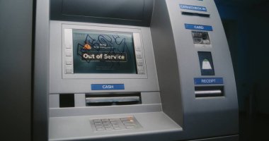 Kapüşonlu Vandal Graffiti İşaretleyici Kalemle ATM ekranını işaretliyor. Mülkiyete zarar verme, hizmet dışı ATM 'ye yasadışı grafitiyle zarar verme. Kamu Alanında Vandalizm.