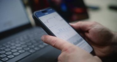 Adam Smartphone ve Laptop 'ta Gerçek zamanlı borsa grafiklerini kontrol ediyor Tablet' te Online Ticaret Dersi izliyor. Çalışanların atölyede çalışma saatlerinde yatırım yapmaları. Kapat..