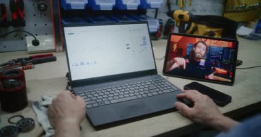 Man, Tablet Bilgisayar 'da Online Trading Webinar' ı izleyerek Gerçek zamanlı borsa grafiklerini ve dizüstü bilgisayarları izliyor. Atölyede İşçi Uzaktan Öğrenme Ticaret Günü 'nde. Kapat..