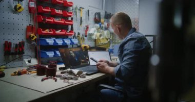 Bilgisayarda Online Ticaret Dersi İzleyen Çalışanlar, Gerçek Zamanlı Borsa Çizelgelerini Akıllı Telefon ve Dijital Tablet kullanarak kontrol ediyor. Atölyede Çalışma Saatlerinde Uzaktan Öğrenme Ticareti.