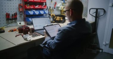 Dijital Tablet ve Laptop kullanarak Gerçek zamanlı borsa tablolarını ve borsa çizelgelerini kontrol ediyorum. Atölyede Çalışma Saatleri sırasında Şifreleme Yatırımları Yapan Adam, Çevrimiçi Ticaretle İş Birleştirmesi