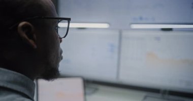 Gerçek zamanlı hisse senedi ve borsa grafiklerini izleyen mali analist. Ticaret Yazılım ile Çoklu Monitör Çalışma İstasyonu ile Bilgisayara Odaklan. Ofiste çalışan Afrikalı Amerikalı İş Adamı.