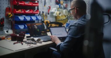 Craftsman Online Trading Webinar 'ı Dizüstü bilgisayarda izliyor, Gerçek zamanlı hisse senetlerini izliyor ve dijital tablet kullanarak borsa grafiklerini değiştiriyor. Atölyede İş Gününde Uzaktan Öğrenme Ticareti.