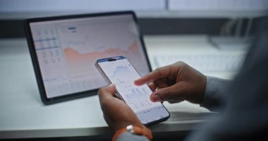 Smartphone ve Dijital Tablet Online Ticaret Uygulamasını kullanarak Afro-Amerikan Borsası Borsa Analizi ve Borsa Çizelgeleri. Ofiste çalışan Yatırım Ajanı. Kapat..