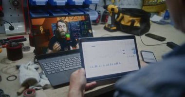 Bilgisayarda Online Ticaret Dersi İzleyen Çalışanlar, Gerçek Zamanlı Borsa Çizelgelerini Akıllı Telefon ve Dijital Tablet kullanarak kontrol ediyor. Man Uzaktan Öğrenme Ticaret Atölyesi 'nde çalışıyor. Kapat..