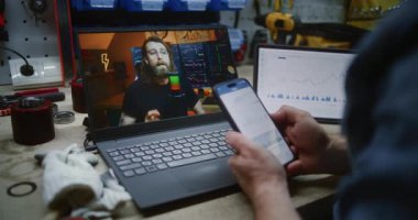 İşçi Online Trading Webinar 'ı Dizüstü bilgisayarda izliyor, Gerçek zamanlı borsa grafiklerini izliyor ve akıllı telefon kullanıyor. Atölyede İnsan Uzaktan Öğrenme Ticaret Günü 'nde. Kapat..