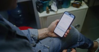 Gerçek zamanlı borsa çizelgelerini kontrol eden adam akıllı telefon kullanıyor. Çalışanların İşyerinde Çalışma Saatleri sırasında Kripto Para Yatırımları Yapması, İş ve Çevrimiçi Ticareti Birleştirmesi. Görüntüyü Kapat