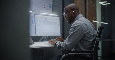 Gerçek zamanlı hisse senedi ve borsa grafiklerini bilgisayarda Multi-Monitor Workstation, Talking and having Call ile birlikte takip eden finansal analist. Afrikalı Amerikalı İşadamı Geceleri Ofiste Çalışıyor.