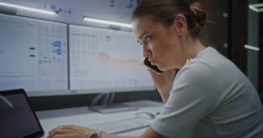 Kadın Borsacı Telefonda Konuşuyor, Gerçek Zamanlı Hisse Senetlerini İzliyor, Bilgisayarda Çoklu İzleme Kurumu ve Dijital Tablet ile Piyasa Tablolarını Değiştiriyor. Yatırım Temsilcisi Geceleri Ofiste Çalışıyor.