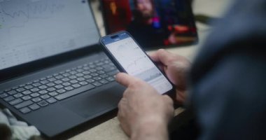 Gerçek zamanlı hisse senedi ve hisselerini dizüstü bilgisayar ve akıllı telefon kullanarak izleyen, dijital tablet üzerinde online ticaret eğitimi izleyen adam. Atölyede İşçi Uzaktan Öğrenme Ticaret Günü 'nde. Kapat..