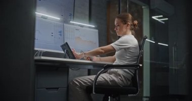 Kadın Finansal Analizci, Çoklu Dijital Aygıtlar ve Bilgisayarda Çoklu Monitör Çalışma İstasyonu ile Gerçek Zamanlı Borsa Çizelgelerini Kontrol Ediyor. Gece Finans Ajansı Ofisi 'ndeki iş kadını.