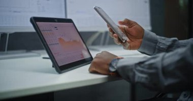 Profesyonel Menkul Kıymetler Borsası İzleme, Akıllı Telefon ve Dijital Tablet Kullanımı Online Ticaret Uygulaması 'nda borsa grafikleri. Ofiste çalışan Afro-Amerikan Yatırım Ajanı. Kapat..