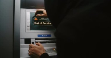 Kapüşonlu Vandal Graffiti İşaretleyici Kalemle ATM ekranını işaretliyor. Mülkiyete zarar verme, hizmet dışı ATM 'ye yasadışı grafitiyle zarar verme. Kamu Alanında Vandalizm.
