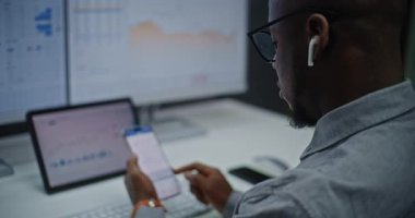 Afro-Amerikan Borsa Komisyoncusu Gerçek-Zaman Borsasını izliyor, Akıllı Telefon 'da borsa grafikleri ve Çevrimiçi Ticaret Uygulamasında Çoklu Dijital Ekranlar. Ofiste çalışan bir yatırımcı. Kapat.