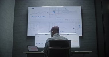 Multi-Monitor Workstation, Real-Time Stocks ve Exchange Market Charts ile bilgisayar üzerinde çalışan bir finans analisti. Afrikalı Amerikalı İşadamı Yatırım Bankası Ofisinde Gece Çalışıyor.