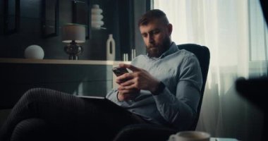 Akıllı Telefon Kullanarak Konsantre Profesyonel Borsa Komisyoncusu Gerçek zamanlı Borsa ve Borsa Çizelgelerini İzliyor. Finans Dairesi 'nin rahat ofisinde çalışan başarılı Yatırım Ajanı.