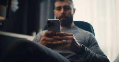 Finansal Analist Smartphone üzerinde çalışıyor, Gerçek zamanlı borsa ve borsa grafiklerini analiz ediyor, yatırım yapıyor. Başarılı İşadamı, Konforlu Yatırım Bankası Ofisinde Çalışıyor. Doli Vuruşu.