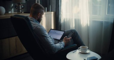 Tablet Bilgisayar ve Smartphone kullanan Profesyonel Borsa İşlemcisi, Çevrimiçi Ticaret Uygulamasında Gerçek Zamanlı Borsa ve Borsa Çizelgelerini İzliyor. Ofiste çalışan Yatırım Ajanı. Sabit Çekim.