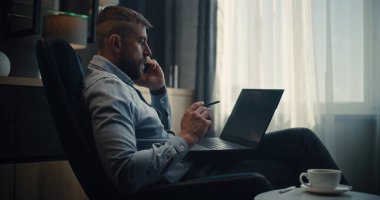 Ciddi Menkul Kıymetler Borsası İşlemcisi Yatırımcıyla Telefon Görüşmesi Yapıyor, Laptop Kullanıyor, Gerçek zamanlı Hisse ve Piyasa Çizelgeleri Çevrimiçi Ticaret Uygulamasında İzleniyor. Ofisteki Profesyonel Yatırım Ajanı. Doli Vuruşu.