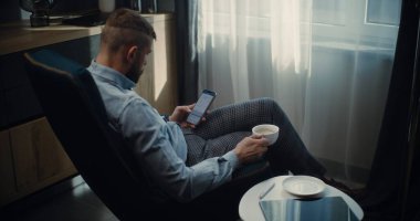 Online Ticaret Uygulamalarında Gerçek Zamanlı Borsa ve Borsa Çizelgelerini İzleyen, Akıllı Telefon Kullanan Bir fincan kahveci Borsacısı. Finansal Büro 'da çalışan başarılı Yatırım Ajanı.