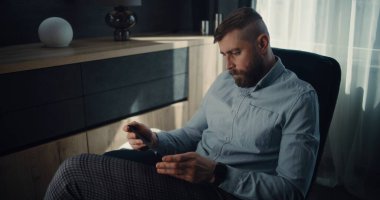 Tablet Bilgisayar üzerinde çalışan Profesyonel Finansal Uzman, Gerçek zamanlı Borsa Çizelgelerini İzleyen, Yatırım Yapan. Konforlu Yatırım Bankası Ofisinde Başarılı İşadamı.