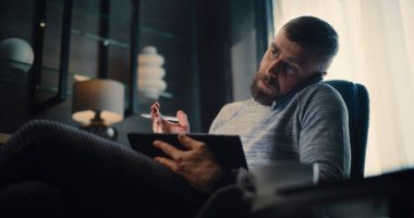 Profesyonel Borsa Komisyoncusu Telefon görüşmesi yapıyor, Gerçek zamanlı hisse senedi ve tablet bilgisayar kullanarak borsa grafiklerini izliyor. Finansal Büro 'da çalışan başarılı Yatırım Ajanı.