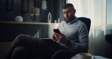 Akıllı Telefon Kullanarak Profesyonel Borsa İşlemcisi Gerçek zamanlı Borsa ve Borsa Tablolarını Analiz Ediyor. Finans Dairesi 'nin rahat ofisinde çalışan başarılı Yatırım Ajanı.