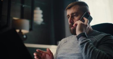 Profesyonel Mali Analistin Telefonu Var, Dizüstü bilgisayarda çalışıyor, Gerçek zamanlı borsa ve borsa grafiklerini izliyor. Başarılı İşadamı Konforlu Yatırım Bankası Ofisinde Çalışıyor.