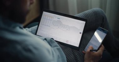 Çevrimiçi Ticaret Uygulamasında Tablet ve Smartphone üzerinde çalışan Finansal Analistin Kapanışı, Gerçek zamanlı Borsa Tabloları İzleme. Başarılı İşadamı Yatırım Bankası Ofisinde Çalışıyor.