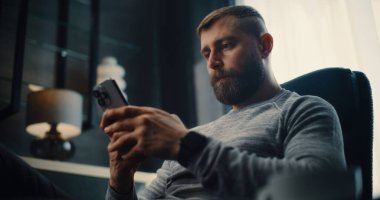 Profesyonel Borsa İşlemcisi Gerçek Zamanlı Borsa İzleme ve Akıllı Telefon Kullanarak Borsa Tabloları, İçme Kahvesi. Finans Dairesi 'nin rahat ofisinde çalışan başarılı Yatırım Ajanı.