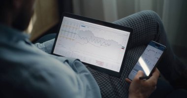 Çevrimiçi Ticaret Uygulamasında Tablet ve Smartphone üzerinde çalışan Finansal Analistin Kapanışı, Gerçek zamanlı Borsa Tabloları İzleme. Başarılı İşadamı Yatırım Bankası Ofisinde Çalışıyor.