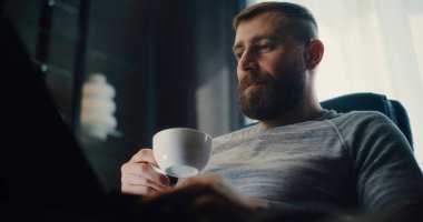 Dizüstü bilgisayarda çalışan profesyonel finans analisti, Gerçek zamanlı hisse senedi ve borsa grafiklerini izleyen, kahve içen. Başarılı İşadamı Konforlu Yatırım Bankası Ofisinde Çalışıyor.