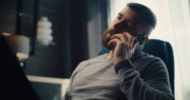 Profesyonel Finansal Uzman Telefon görüşmesi, Laptop üzerinde çalışmak, Gerçek zamanlı hisse senetleri ve borsa grafiklerini izlemek. Başarılı İşadamı Konforlu Yatırım Bankası Ofisinde Çalışıyor.