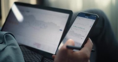 Smartphone ve Tablet Bilgisayar 'da çalışan başarılı iş adamının Çevrimiçi Ticaret Uygulamasında Gerçek Zamanlı Borsa ve Borsa Çizelgelerini Göstermesi. Ofisteki Profesyonel Finans Uzmanı.